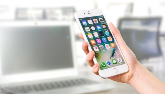 Phone held in front of a laptop